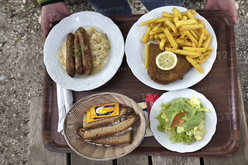Sausages with sauerkraut and bread and cordon bleu with French fries served on a tray in a garden restaurant, Franconia, Bavaria, Germany