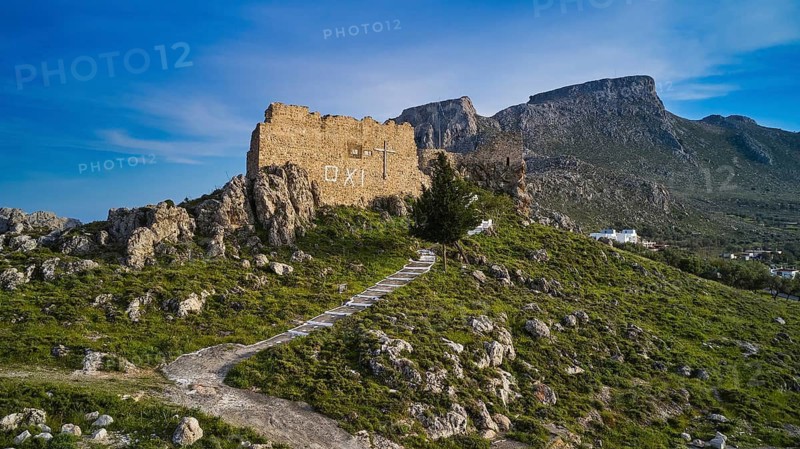 Drone shot, stone ruin on hill with path, embedded in mountainous landscape in front of blue sky, Archangelos, castle, place, castle of Archangelos, Rhodes, Dodecanese, Greek Islands, Greece