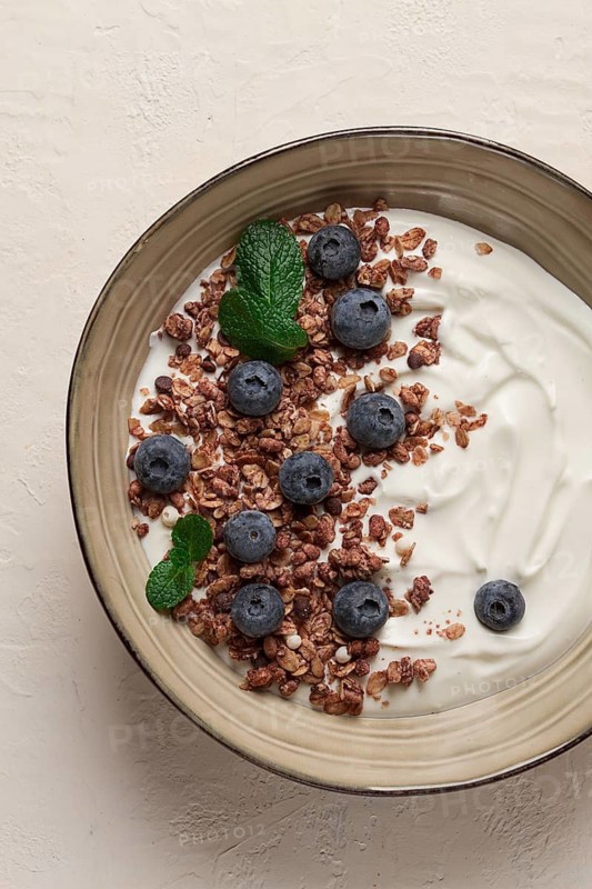 Yogurt with chocolate muesli, with berries, blueberries, breakfast, close-up, fork on top, no people