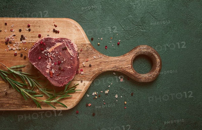 Fresh, raw rib eye steak, on a chopping board, top view, no people