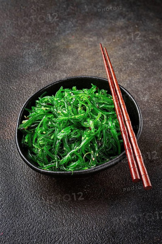 Chuka salad, made from fresh seaweed, with sesame dressing, served in a black bowl, with chopsticks