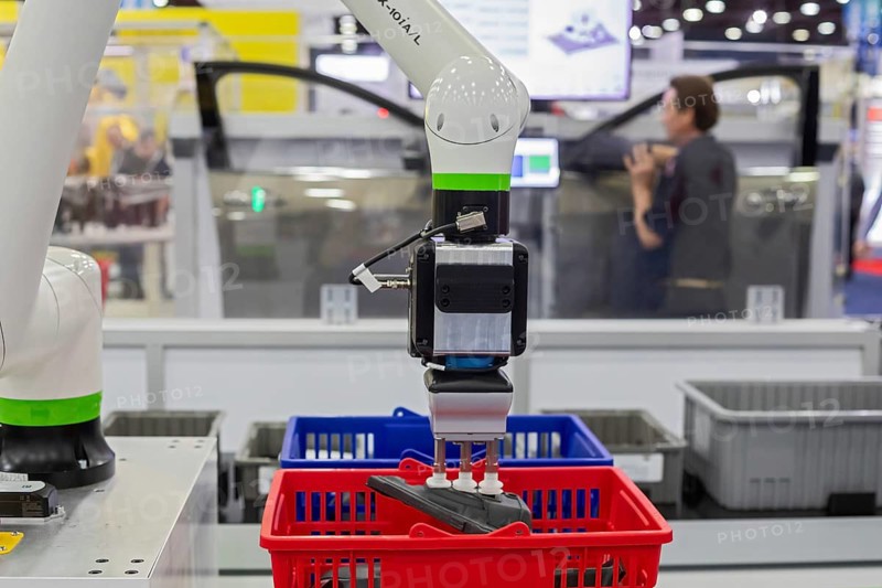 Detroit, Michigan - More than 800 exhibitors displayed at Automate, North America's largest robotic and automation event. A robot picks a part that is the next thing the worker needs in his auto assembly job