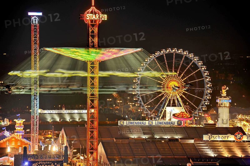 View over the Wies'n at night with illuminated carousel, Ferris wheel, stalls, beer tents and rides, Oktoberfest, Wiesn, Munich, Upper Bavaria, Bavaria, Germany