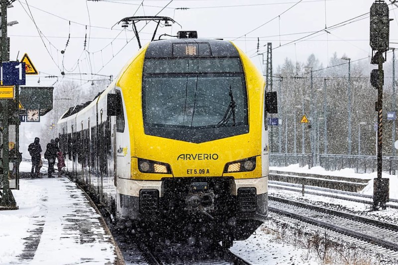 Regional train from Arverio on its way through a winter landscape in snowfall. The railcar train is painted by the Baden-Württemberg mobility brand bwegt. A train on the line in the Deutsche Bahn AG rail network. Amstetten, Baden-Württemberg, Germany