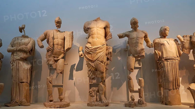 From left to right: Sterope, wife of Oinomaos, Oinomaos with helmet and spear, father of the gods Zeus, Prince Pelops, Hippodameia, east pediment of the Temple of Zeus, preparations for the chariot race between Pelops Oinomaos, fragmented ancient marble statues in an exhibition, several headless figures, Olympia Archaeological Museum, Olympia, Peloponnese, Greece