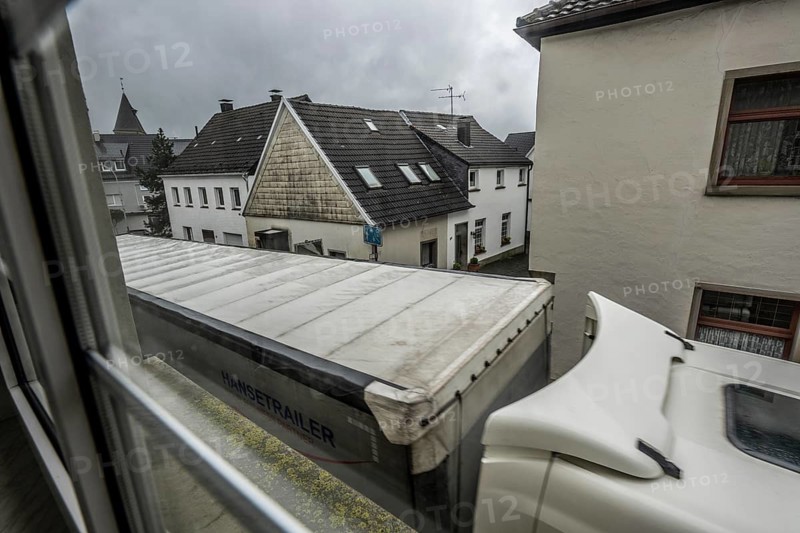 City centre traffic, lorry driving through the town of Breckerfeld, narrow passage in Frankfurter Straße, right next to the residential buildings, Ennepe-Ruhr district, North Rhine-Westphalia, Germany