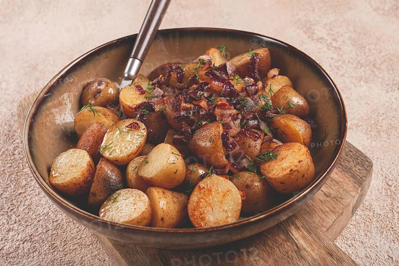 Crispy roasted potatoes with saut?ed onions and herbs served in a rustic bowl