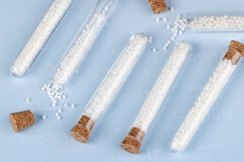 Corks and test tubes filled with white globules on a blue background