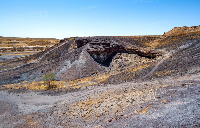 Dry landscape with yellow grass and black volcanic hills, Burnt Mountain, Damaraland, Kunene, Namibia