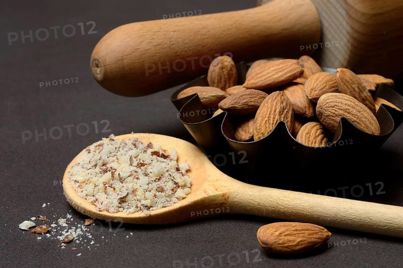 Almonds and ground almonds in cooking spoon, Prunus amygdalus