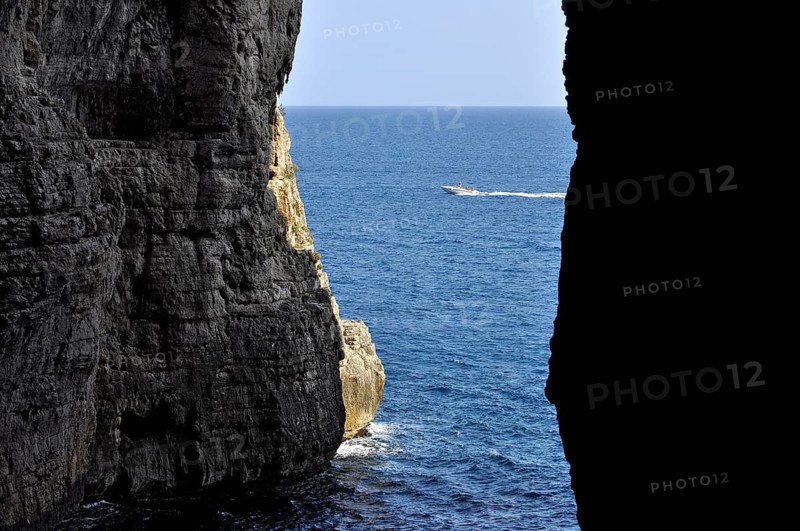 Karst cave Grotta del Turco, Cave of the Turk, Montagna Spaccata, Split Mountain, Gaeta, Tyrrhenian Sea with speedboat, Latina, Lazio, Italy