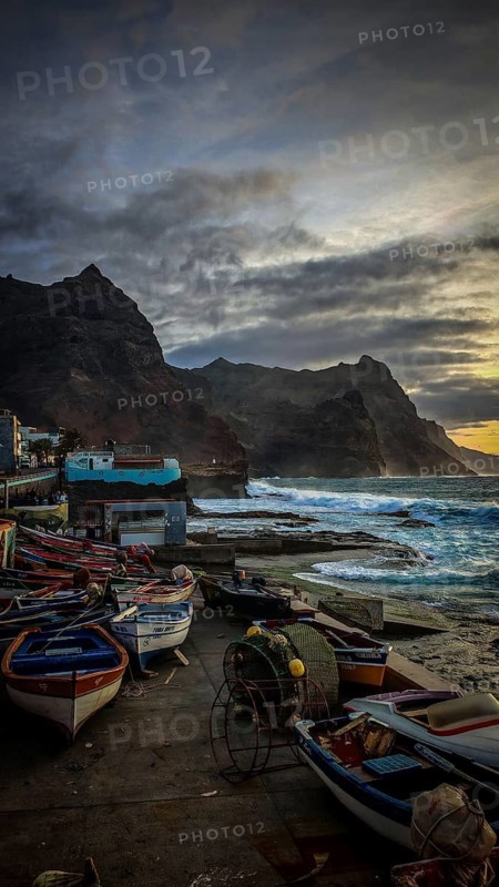 Colourful boats along a rocky seashore with dramatic skies, romantic harbor scene in the evening light, Ponta do Sol, Santo Antao, Cabo Verde, Cape Verde, Cape Verde