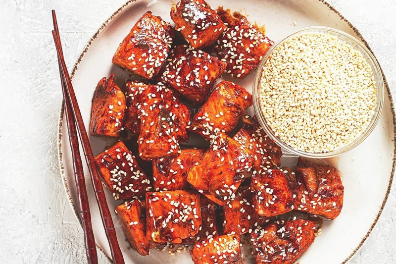 Fried pieces of salmon teriyaki with sesame seeds, top view