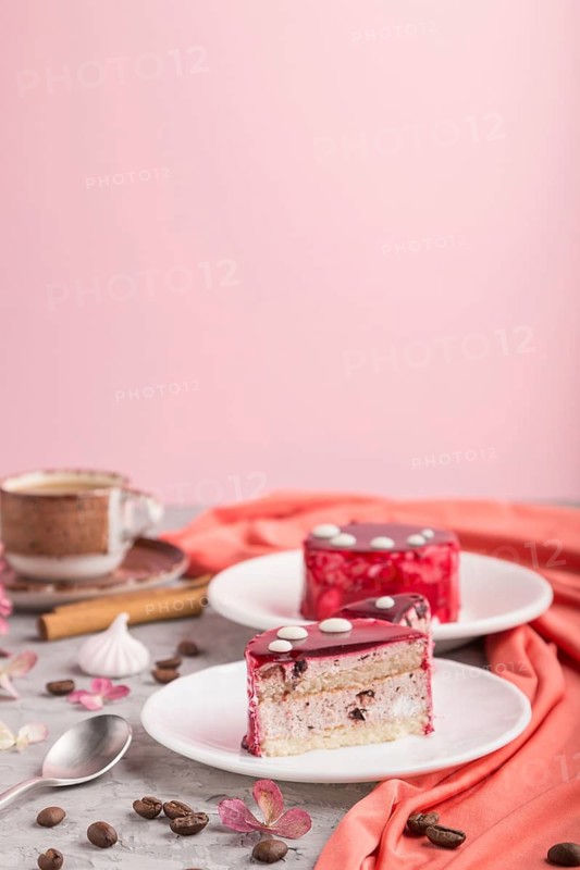 Red cake with souffle cream with cup of coffee on a gray and pink background and red textile. side view, copy space