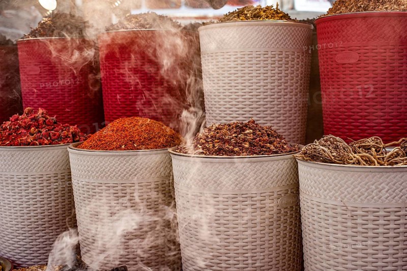 Dubai, United Arab Emirates. July 1st 2019 Incense burning alongside coloured spices for sale in Dubai Creek Souk, UAE