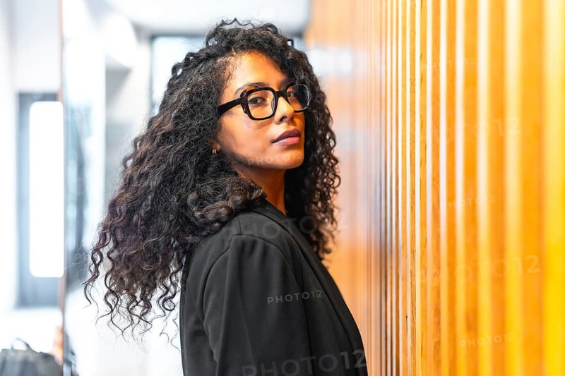 Beauty latin businesswoman turning to look at camera with confidence inside a financial modern building
