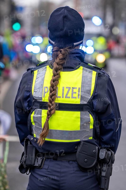 Rose Monday procession in Düsseldorf, emergency services, secure, accompany the move, policewoman with bouquets of flowers, Strüsschen, in some cases heavy rain, North Rhine-Westphalia, Germany