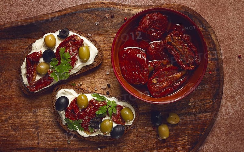 Sandwich with cream cheese, dried tomatoes, olives, breakfast, top view