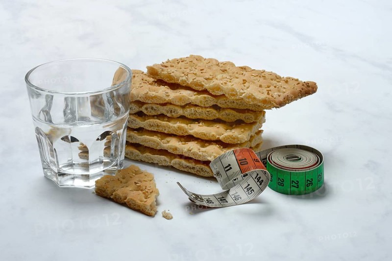 Crispbread and glass of water, measuring tape