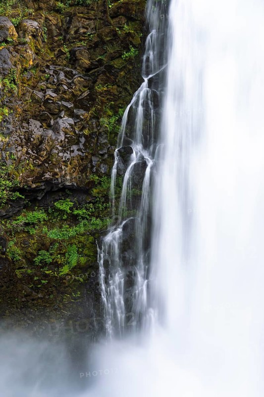 Detailed view of waterfall, falling water next to moss-covered basalt wall with ferns, long exposure, Huilo Huilo Biological Reserve, Los Ríos Region, Chile