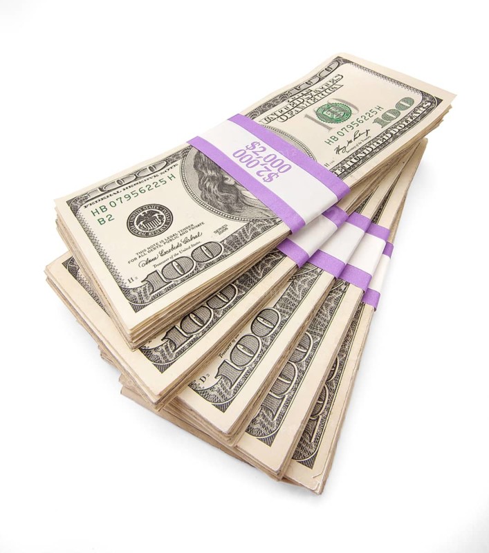 Ten thousand dollars in stacks of one hundred dollar bills isolated on white