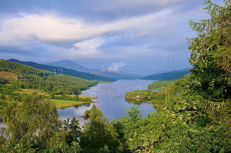 Lake surrounded by green hills under a sky with moving clouds, Queens View, Fincastle, Pitlochry, United KingdomScotland, United Kingdom, Great Britain