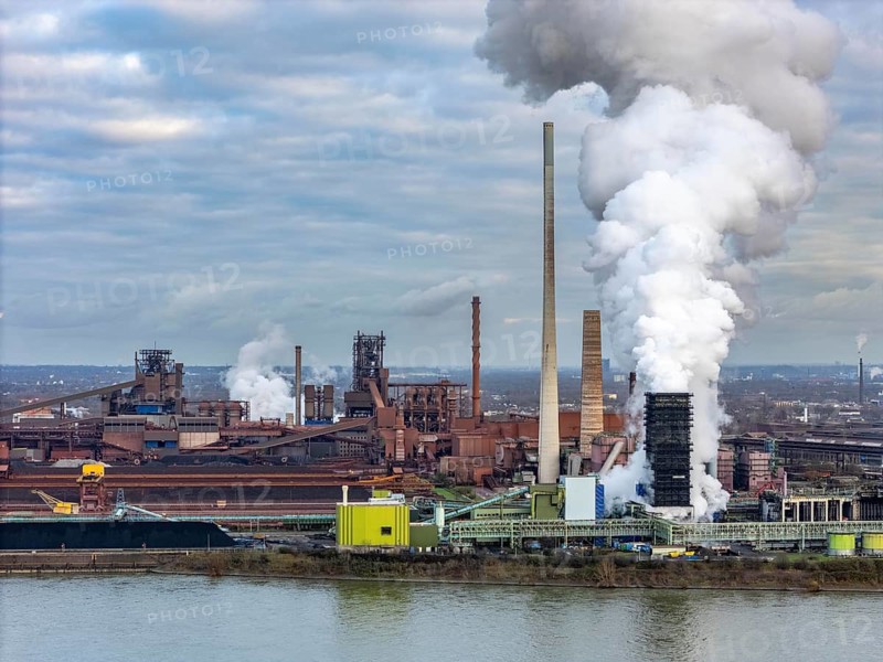 Industrial backdrop of the ThyssenKrupp Steel steelworks in Duisburg-Bruckhausen, on the Rhine, blast furnaces, Schwelgern coking plant, extinguishing cloud, Duisburg, North Rhine-Westphalia, Germany