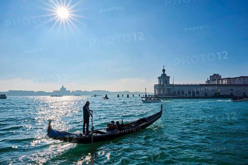 Wild carnival hustle and bustle on the 'Canal Grande' with decorated boats and masked people in Venice, Italy