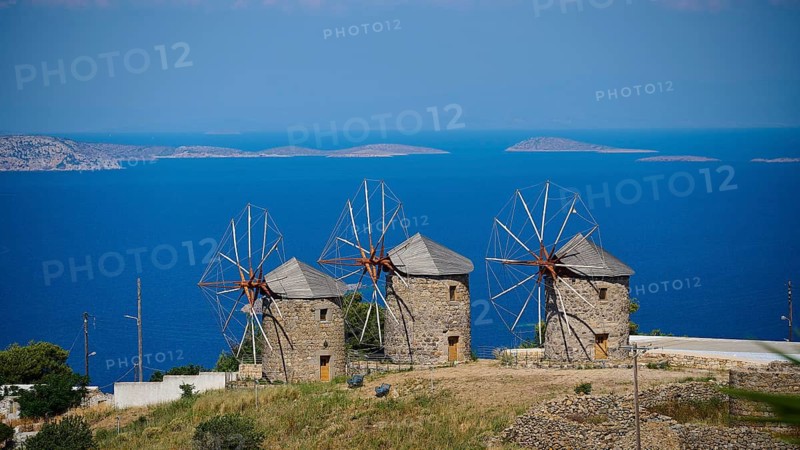 Three old windmills with a wide blue sea in the background under a clear sky, windmills, on a ridge, above Chora, main town Patmos, Patmos, old town, Dodecanese, Greek Islands, Greece