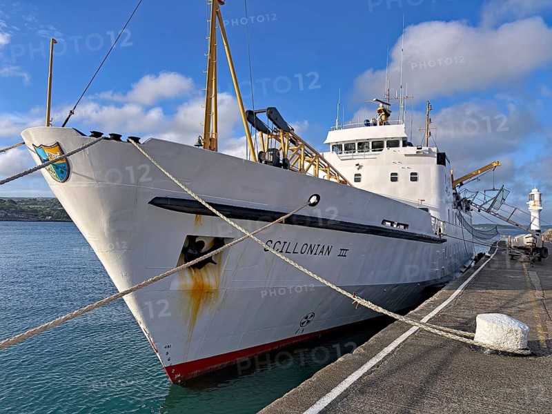 A large ship is moored at the quay with ropes, surrounded by sea and sky under a slightly cloudy sky, ferry to the Isles of Scilly, Penzance, Cornwall, Great Britain