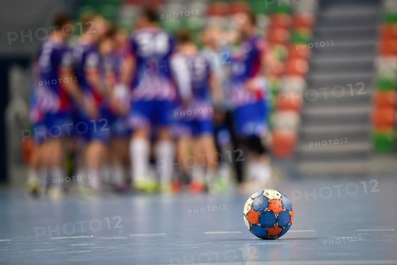 The ball on the parquet and handball team in the background in Lubin, Poland