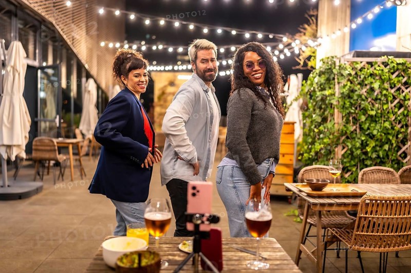 Multiethic friends choreographing while dancing together at night party in the terrace of a urban bar