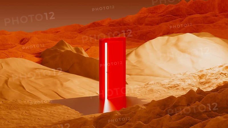 A bright, red door rests in the middle of a surreal desert landscape. A light glows from the door, reflected in a shallow body of water