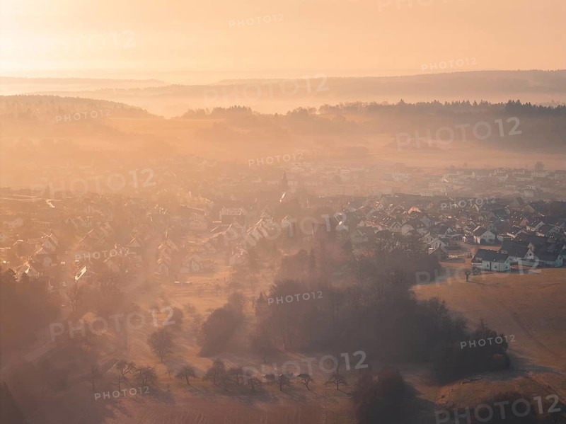 Picturesque village in rolling hills in early morning fog, Gechingen, Calw district, Germany
