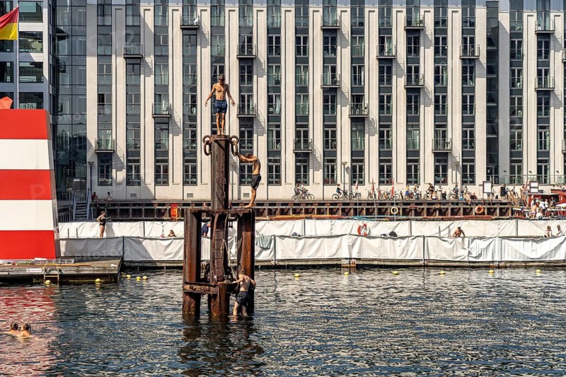 Young people diving into the harbour, Fisketorvet harbour swimming pool in Copenhagen, Denmark