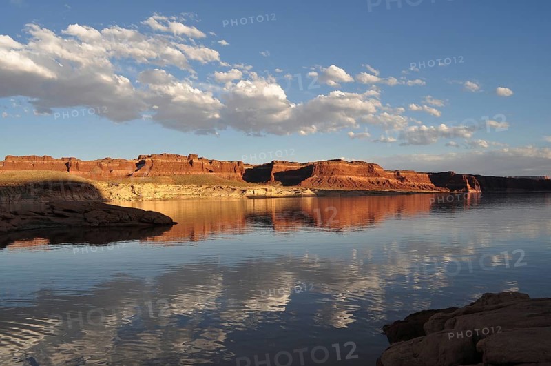 Perfect reflection of a vast rocky landscape with clouds in calm waters, Lake Powell, Arizona, USA