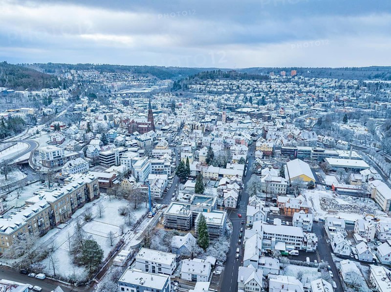 Aerial view of a snowy town with houses and mountains in the background, peaceful winter atmosphere, Nagold, Black Forest, Germany