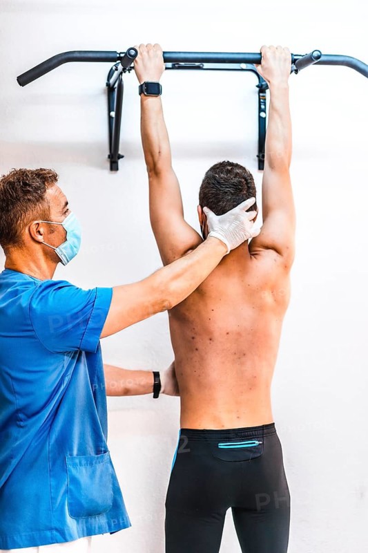 Physiotherapist with the hand on the neck of a patient in a dominated. Physiotherapy with protective measures for the Coronavirus pandemic, COVID-19. Osteopathy, sports chiromassage