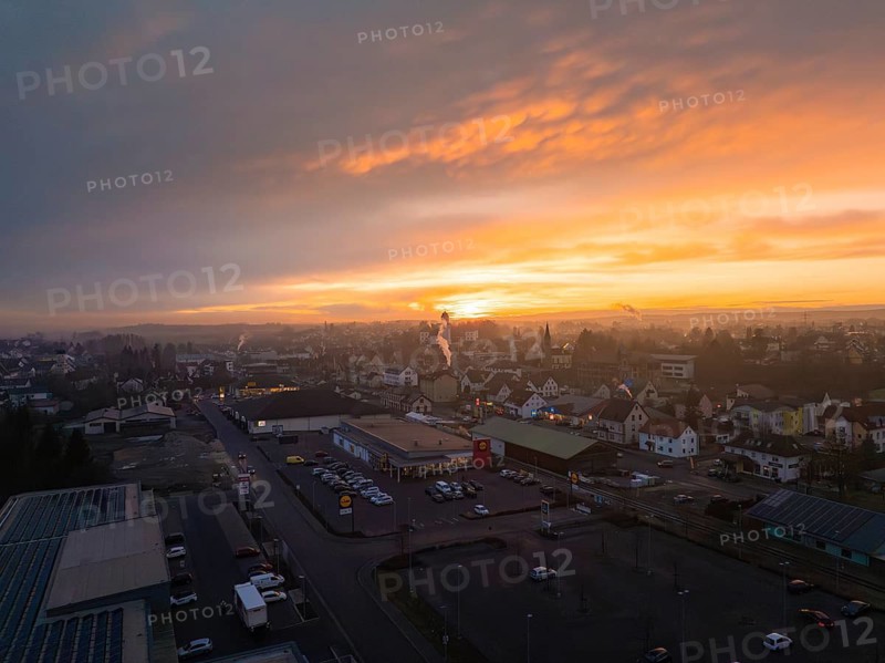 Cityscape at sunset with glowing sky and dark silhouettes of buildings, Meßkirch, Sigmaringen district, Germany