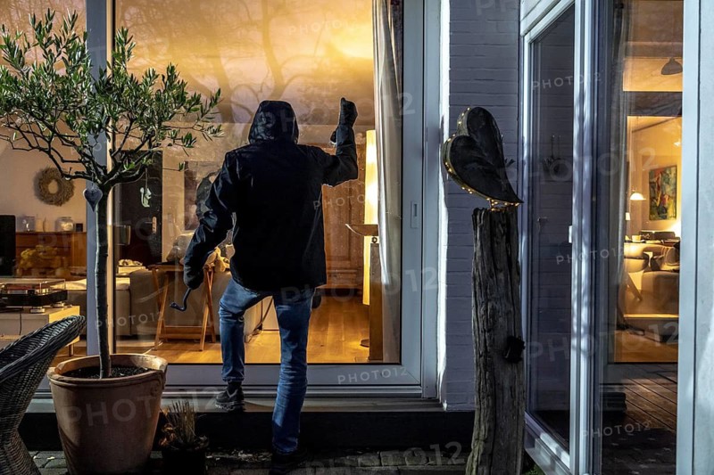 Symbolic image of a burglary, perpetrator spies on a flat from the garden side