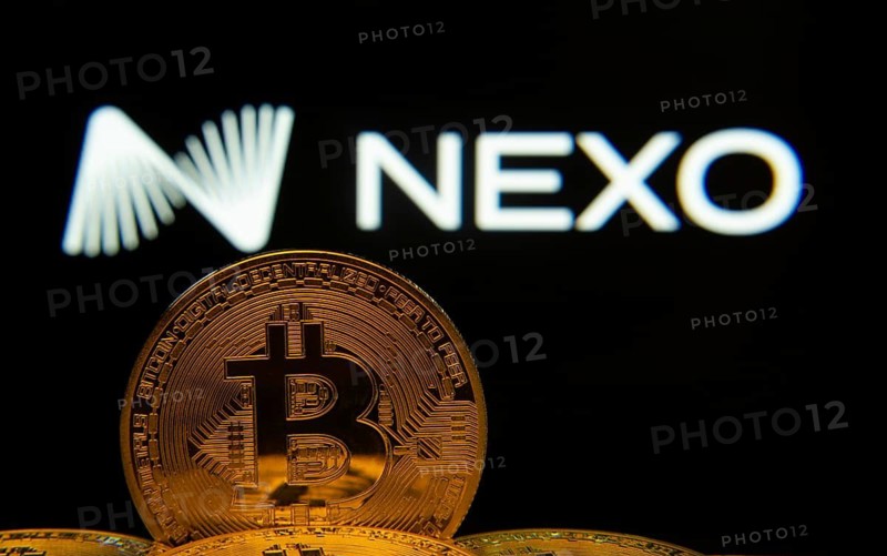 Dhaka, Bangladesh- 06 Sep 2025: Close-up of Bitcoin coins with the Nexo logo visible on a screen in the background