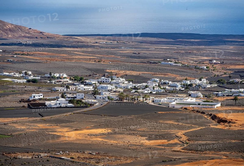 Town with white houses in dry volcanic landscape with fields, Lanzarote, Canary Islands, Spain