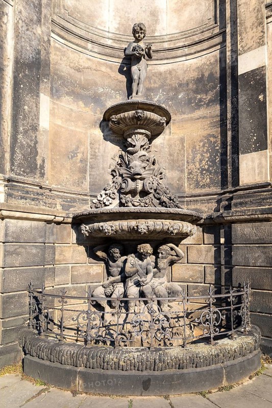 Sandstone fountain with figures and decorations on the outer façade of the Zwinger, Dresden, Saxony, Germany