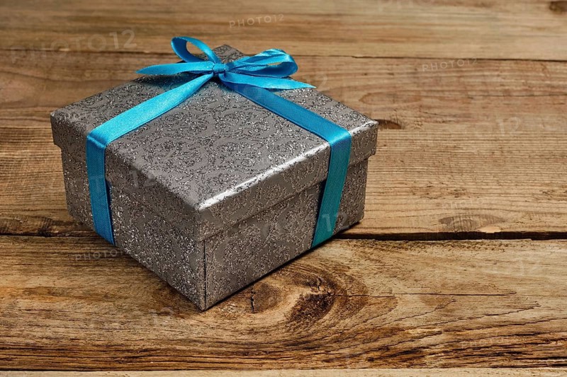 Gift birthday Christmas present concept, silver gift box with blue ribbon on old wooden background