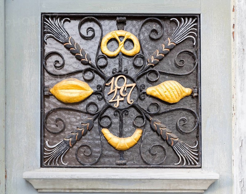 Various signs for a metal bakery as door decoration, old town centre of Cadolzburg, Bavaria, Germany