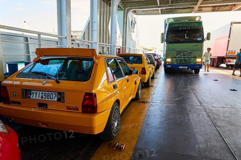 Yellow cars and a green truck on a ferry, bright lighting, rally cars, Rio-Antirrio ferry, cable car bridge, Gulf of Corinth, Patras, Peloponnese, Greece