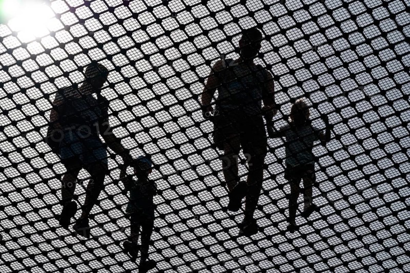 Visitors balance against the light on a steel net on the observation tower on the Usedom treetop walk, Baltic resort Heringsdorf, Usedom Island, Mecklenburg-Western Pomerania, Germany
