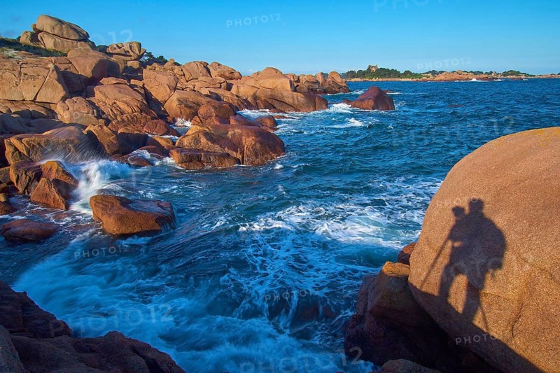 Large rocks on the Granit Rose coast, with the silhouette of a photographer, Ploumanach, Cote De Granit Rose, Cotes-d Armor department, Bretange, France
