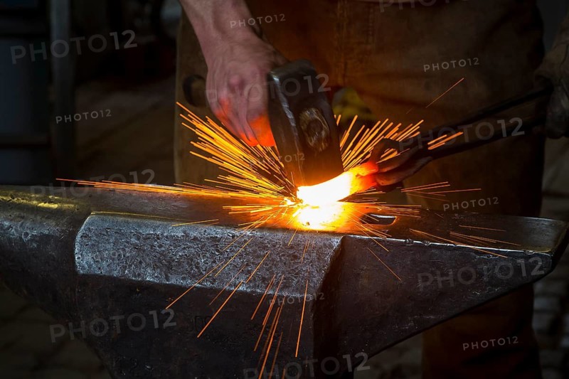 Sparks spray, a blacksmith forging, working at the Ehnert forge in Dresden-Bühlau, Saxony, Germany