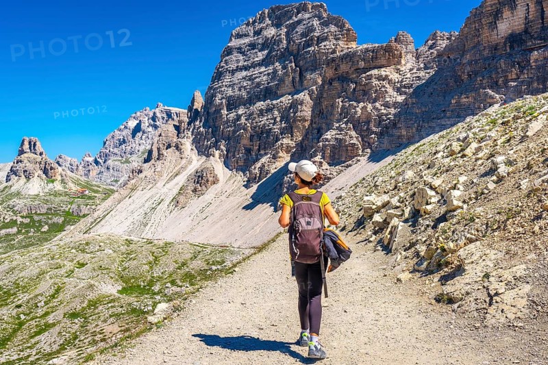 Female hiker enjoying a sunny summer day exploring the breathtaking mountain landscape of tre cime di lavaredo in the dolomites
